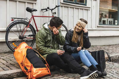 Men sitting on bicycle in city