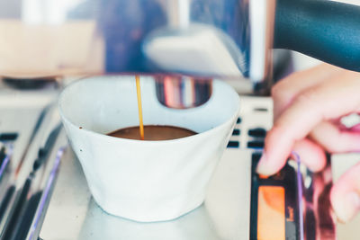 Close-up of hand holding coffee cup
