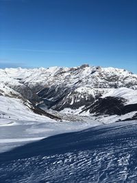 Scenic view of snowcapped mountains against clear blue sky