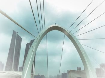 Low angle view of suspension bridge against sky