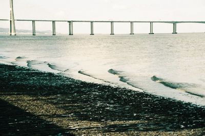 Bridge over sea against sky during winter