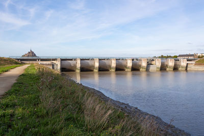 Bridge over river against buildings