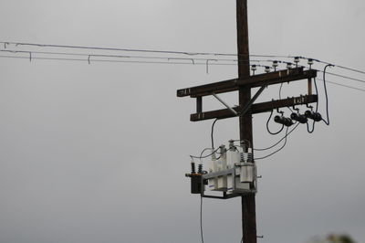 Low angle view of overhead cable car against sky