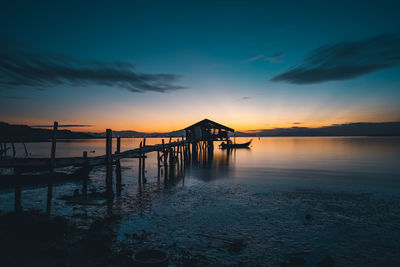 Pier over sea against sky during sunset