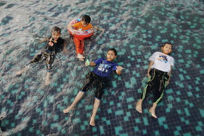 High angle view of happy boys swimming in water