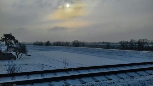 Scenic view of frozen landscape against sky during winter