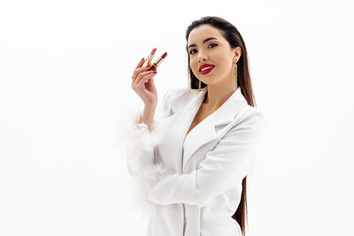 Portrait of a beautiful girl holding a lipstick on white background