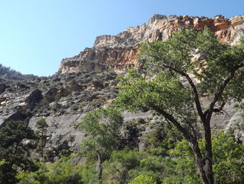 Low angle view of rocky mountains against clear sky