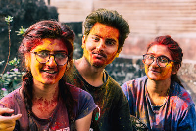 Portrait of smiling friends covered with powder paint outdoors
