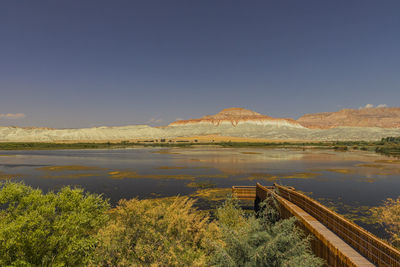 Scenic view of lake against clear blue sky