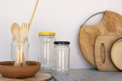 Close-up of glass jar on table against wall at home