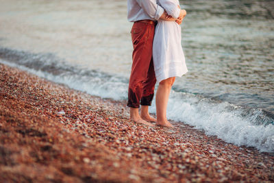 Low section of man standing on beach