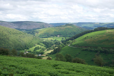 Scenic view of green landscape and mountains against sky