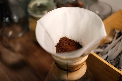 Glass containing filter paper and ground coffee