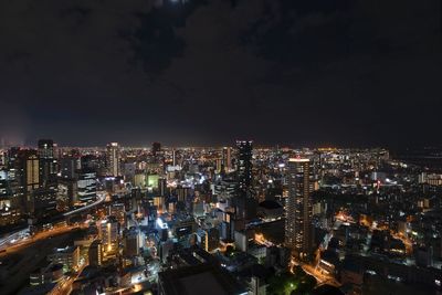 Illuminated cityscape against sky at night