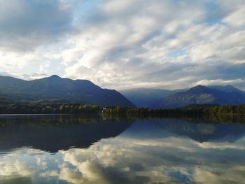 Scenic view of lake by mountains against sky