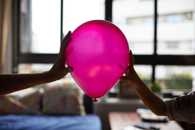 Close-up of hand holding balloons