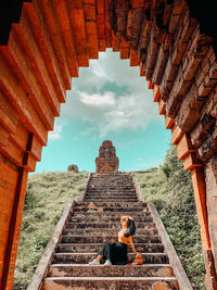 Low angle view of woman at temple against sky