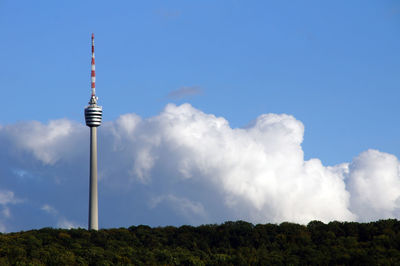 Low angle view of communications tower against cloudy sky