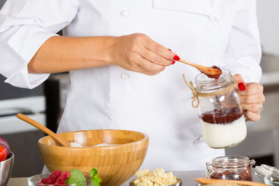 Midsection of chef preparing food in commercial kitchen