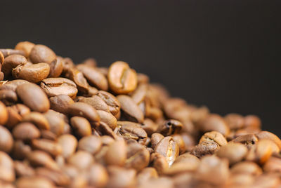 Close-up of coffee beans on table against black background