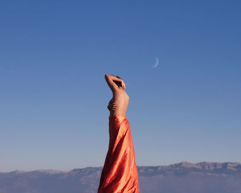 Low angle view of person against blue sky