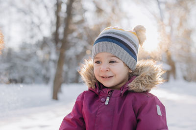 Portrait of cute girl standing on snow