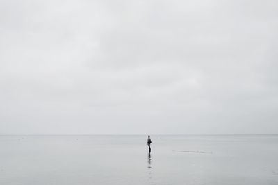 Person standing on beach against sky