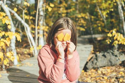 Portrait of young woman holding plant