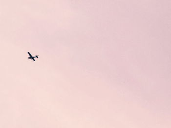 Low angle view of silhouette airplane flying in sky