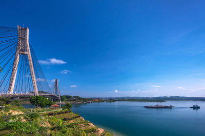 View of bridge over bay against blue sky