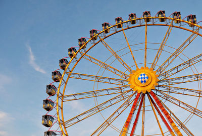 Low angle view of ferris wheel against clear blue sky