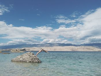 Full length of woman diving from rock into sea