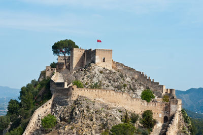 Low angle view of castle on mountain against sky