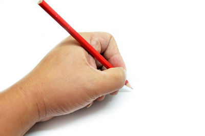 Close-up of hand holding paper over white background