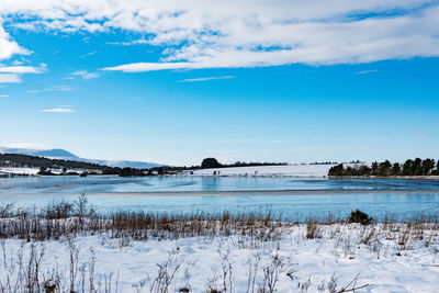 Scenic view of lake against sky during winter