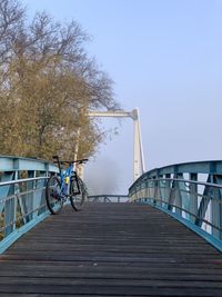Bicycle on footbridge against sky