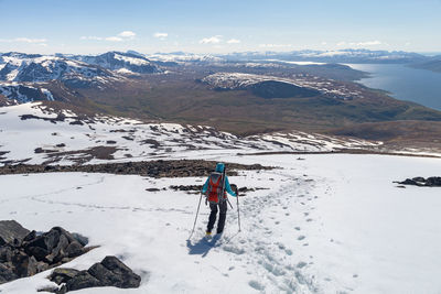 Woman walking on snow covered mountain