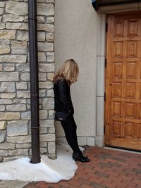 Side view full length of woman standing by door