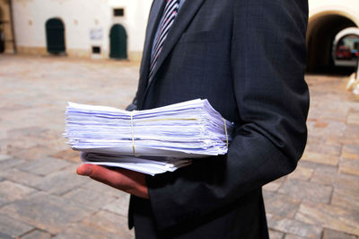 Midsection of man holding umbrella