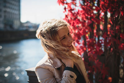 Young woman talking on phone by river