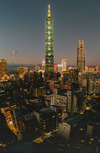 Aerial view of illuminated buildings in city against sky at night