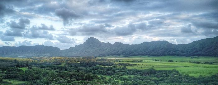 Scenic view of field and mountains against sky