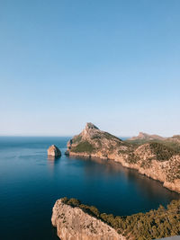 Scenic view of sea and mountains against clear blue sky