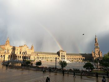 Panoramic view of rainbow over river in city