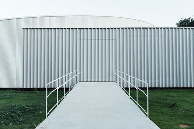 Footbridge leading towards corrugated iron