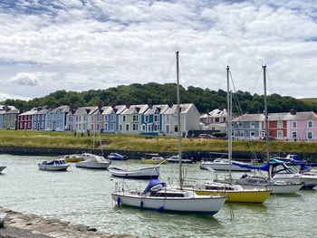 Boats moored at harbor against buildings in city