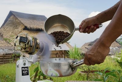 Midsection of person preparing food in container