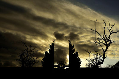 Low angle view of silhouette tree against dramatic sky