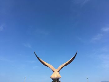 Low angle view of deer on blue sky